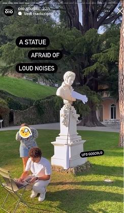 An Instagram story by öiō studio captioned “A statue afraid of loud noises”, the arm raised over the bust.