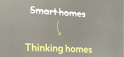 A projected slide: “Smart homes” struck through, an arrow pointing down to “Thinking homes”.