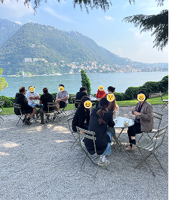 The group at café tables on the lakeside terrace during a break.