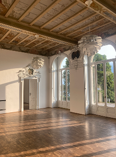 The empty frescoed hall used as the workshop studio, with tall windows onto the garden.