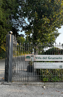 The wrought-iron gate of Villa del Grumello in Como, with the villa's name on a sign.